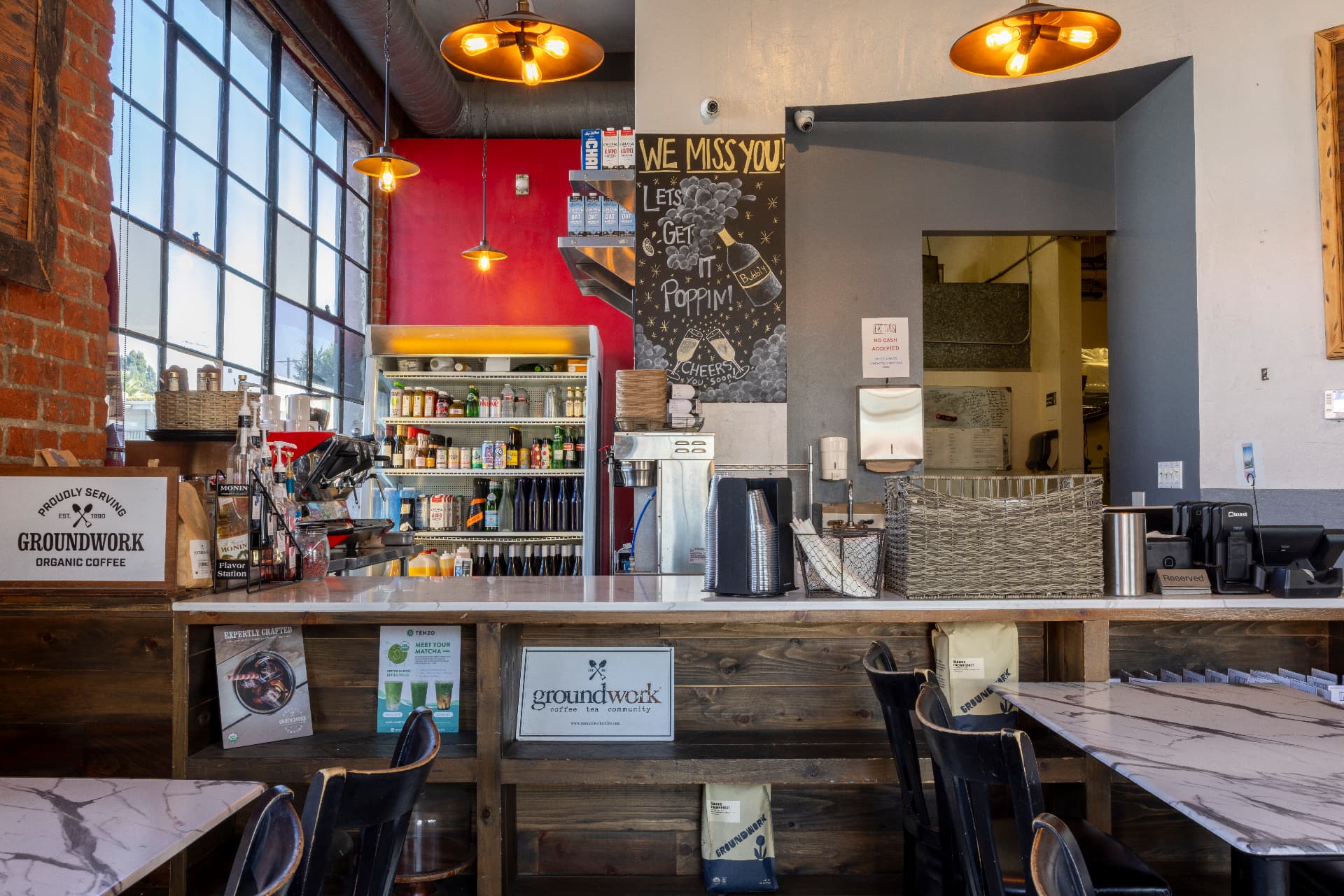 Eat This Café coffee counter with exposed brick, tall windows and amber pendant lights