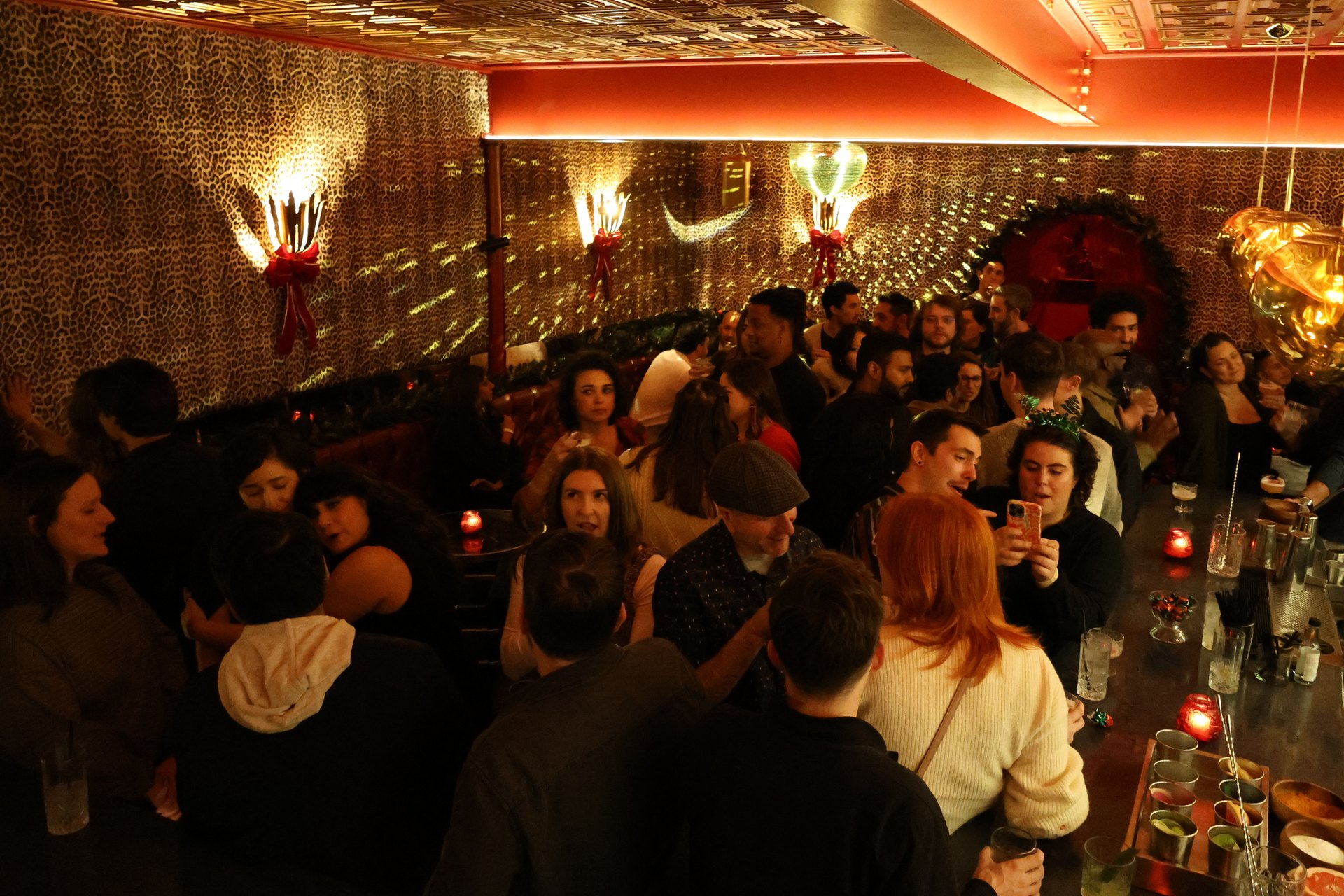 Guests mingling with cocktails at a festive evening party inside Jaguar Room